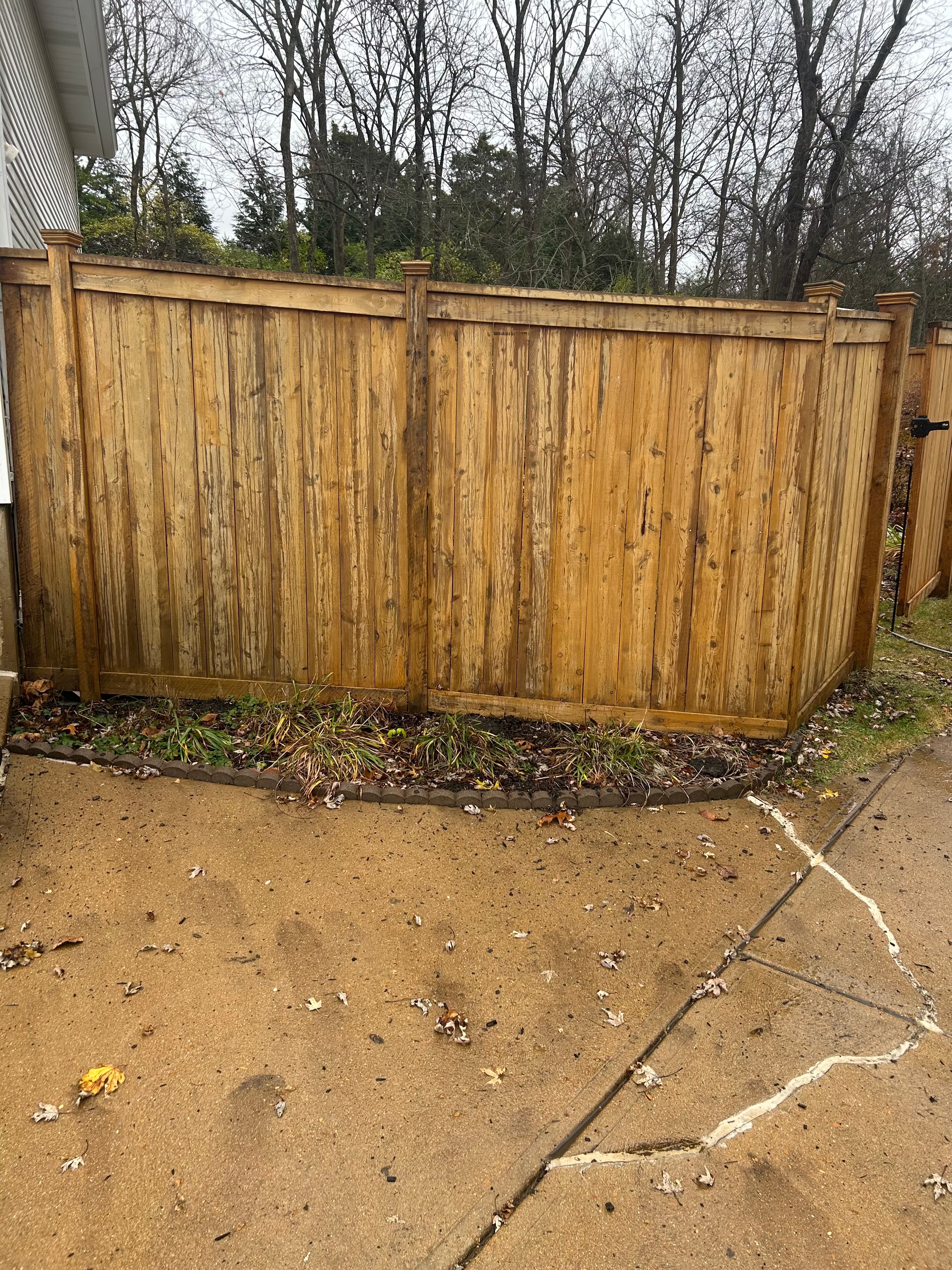 Weathered wood privacy fence before restoration